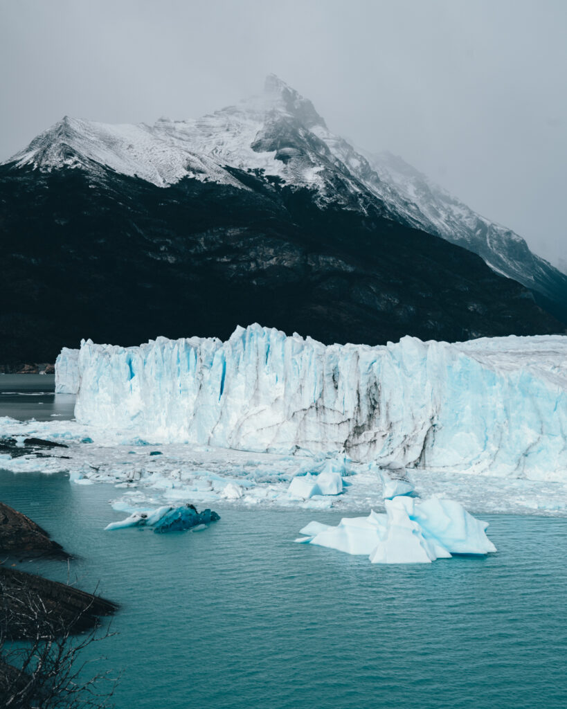a blue ice wall of Perito Moreno glacier in Argentina, southern Patagonia with mountains behind